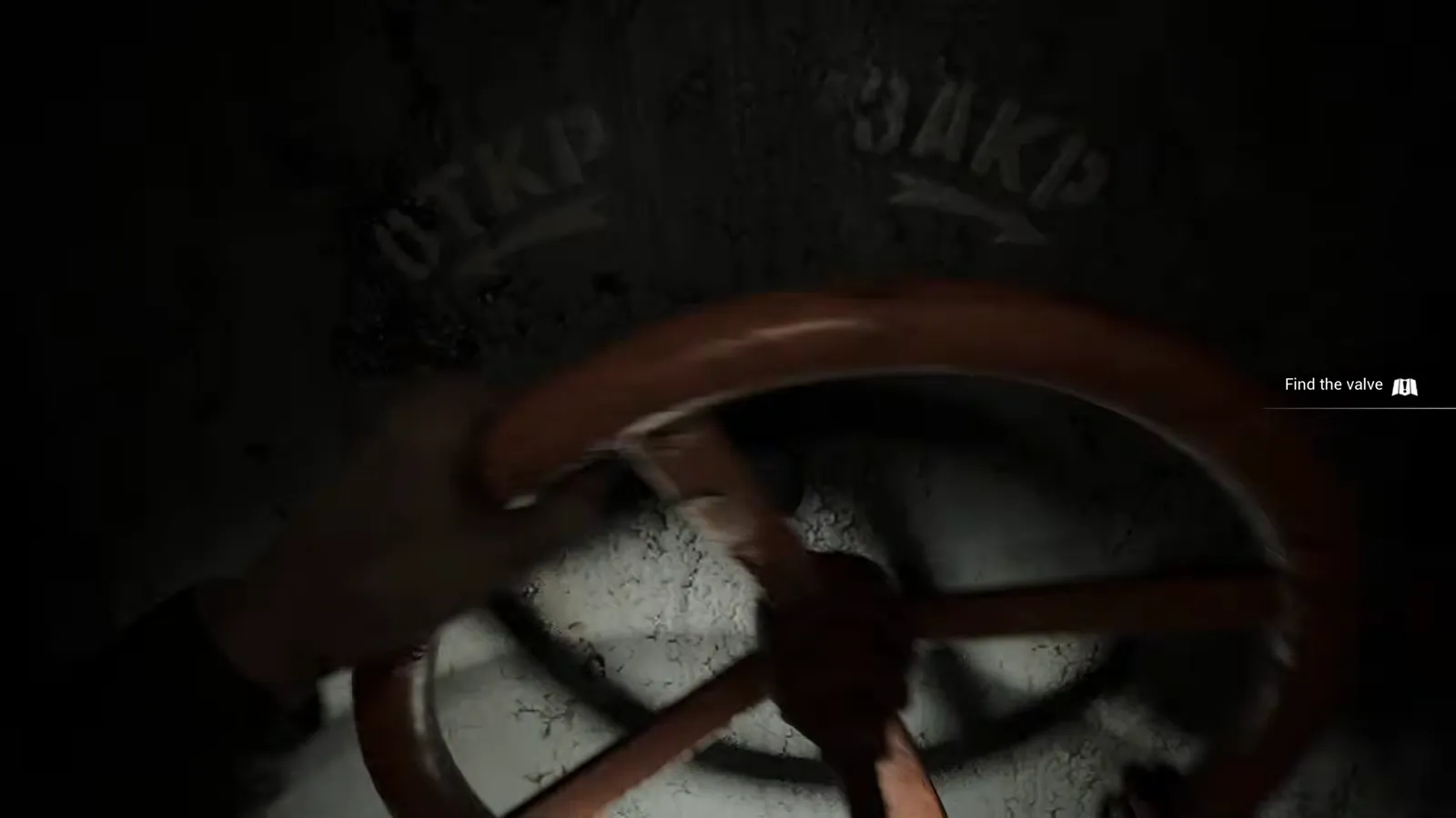 First-person hands gripping and rotating an orange valve wheel on a heavy industrial door mechanism