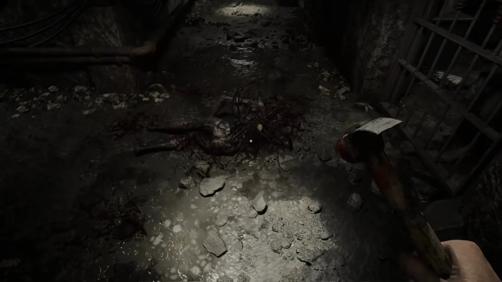 Hammer held in the player view over a blood-stained floor tile lit by a narrow flashlight beam